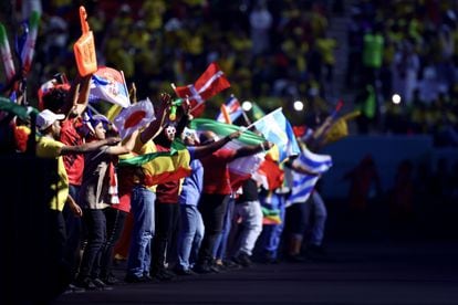 Participantes en la inauguración ondean banderas de las 32 selecciones que disputan la Copa del Mundo.