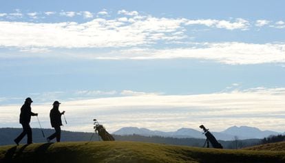 Golfistas jugando frente a los Alpes Bávaros, en el sur de Alemania.
