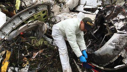 Un agente de la policía trabaja cerca de los restos del avión siniestrado en La Unión (Colombia).