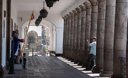 Un turista fotografiando a la guardia presidencial en el palacio de Carondelet, en Quito.