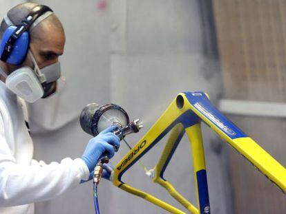 Un trabajador pinta un cuadro de una bicicleta de Orbea.