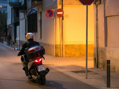 Una motocicleta circula por una calle del barrio de Sants.