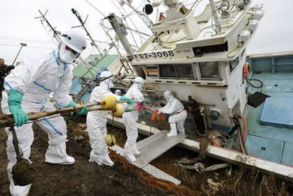 Voluntarios limpian un barco de radiactividad en Fukushima.