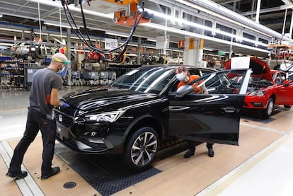 Dos trabajadores en la línea de producción de una fábrica de coches.