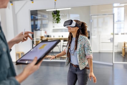 Young woman trying to use virtual reality glasses in the office.