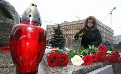 Una mujer deja una rosa en el monumento a las víctimas de la represión estalinista en la plaza Lubyanka, frente a la sede del antiguo KGB, en Moscú.