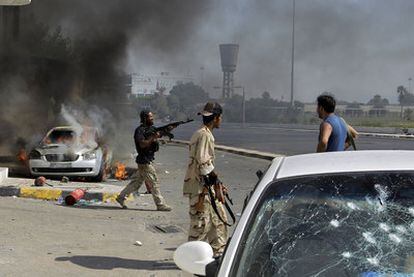 Rebeldes libios disparan contra soldados leales a Gadafi durante los combates registrados ayer en el centro de Trípoli.