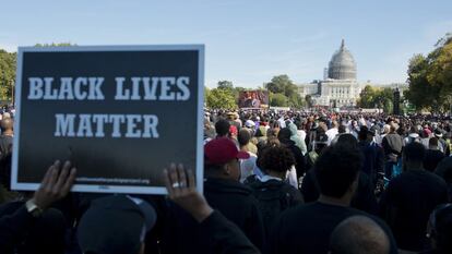 Un asistente lleva un cartel del movimiento 'Las vidas negras importan' durante las protestas por las muertes de negros desarmados a manos de la policía en Estados Unidos