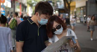 Turistas en Seúl se protegen con mascarillas este jueves.