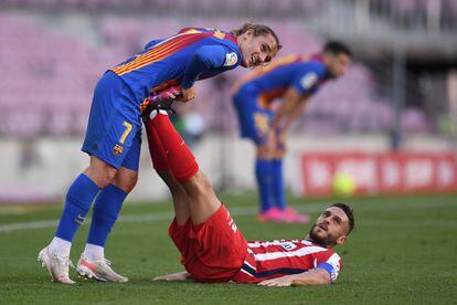 Koke, tumbado en el suelo, recibe la ayuda de Griezmann para estirar los gemelos durante los últrimos minutos del Barcelona-Atlético disputado el sábado en el Camp Nou. / David Ramos (GETTY IMAGES)