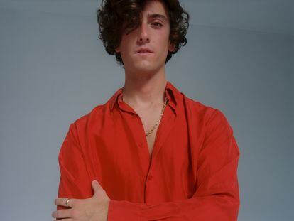 Álvaro Lafuente viste camisa de seda roja Gabriela Coll con anillo Trinity y collar, ambos Cartier.