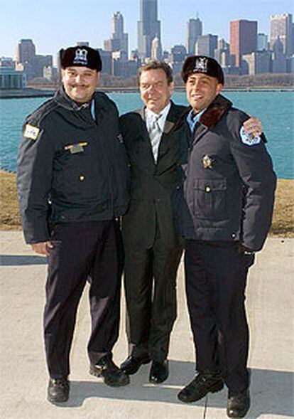 El canciller Schröder posa junto a dos policías el jueves en Chicago.