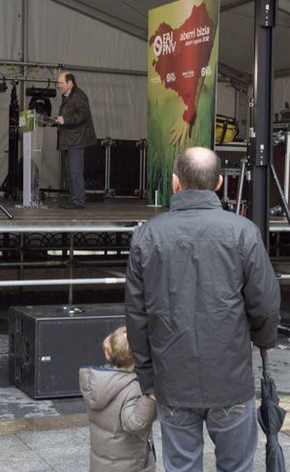 Un hombre escucha la intervenci&oacute;n de Andoni Ortuzar en la Plaza Nueva de Bilbao.