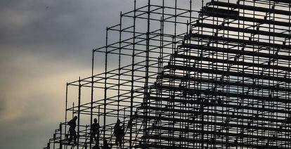 Operarios trabajan en el montaje de unas gradas