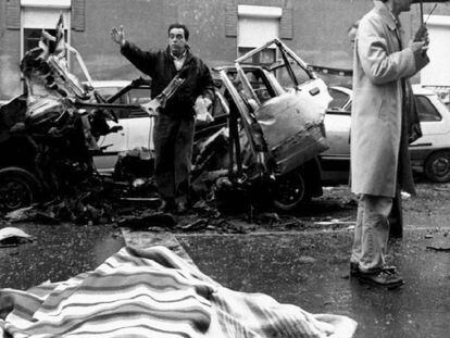 El cadáver del comandante Cortizo, cubierto por una manta, junto al coche destrozado por la bomba lapa.