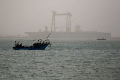 Según Bloomberg, unas 100 embarcaciones están paradas a la espera de que se reabra el paso. En la imagen, un barco navega en Suez este miércoles, cerca del Canal, a través del clima arenoso.