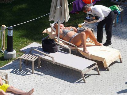 Un camarero atiende a una turista en la piscina de un hotel en Palma de Mallorca. 
