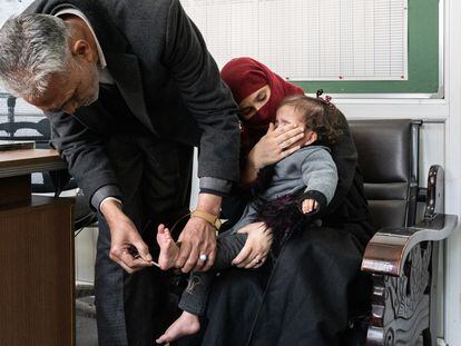 Un médico pasa una llave por el pie de un bebé en el Hospital de Niños Indira Gandhi, en Kabul, para probar su sensibilidad.