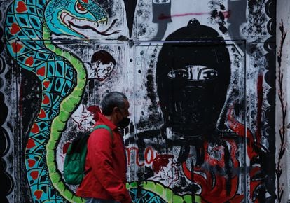 Una persona pasa frente a un grafiti alusivo al Escuadrón Zapatista "La Extemporánea" en Ciudad de México