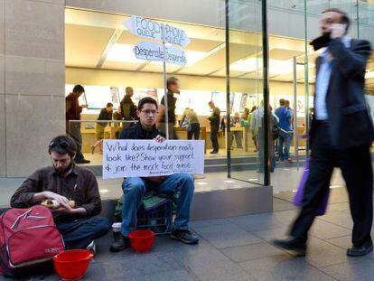 Protesta contra el consumismo en una tienda de Apple en Sidney. A un lado la cola del iPhone, al otro, los que pasan hambre.