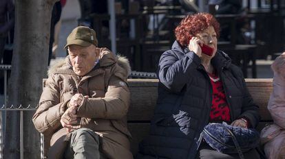 Un hombre y una mujer, ambos de avanzada edad, sentados en el centro de Sevilla.