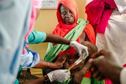 Una mujer sostiene a su bebé para que le midan el brazo para comprobar si padece desnutrición en el hospital de Selibaby, al sur de Mauritania. En esta unidad especial, tratan los casos más graves, dentro del programa para reducir la mortalidad de niños de hasta cinco años de Acción contra el Hambre en el departamento de Guidimakha, uno de los más afectados por la crisis alimentaria.