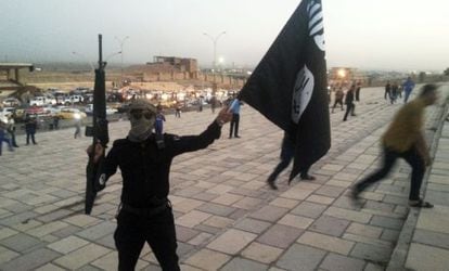 Un miliciano levanta una bandera del Estado Islámico, tras la toma de Mosul en junio de 2014.