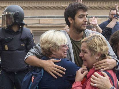 Dos mujeres lloran en el exterior del instituto Can Vilumara de L'Hospitalet de Llobregat ante el despliegue policial, el 1 de octubre de 2017. En vídeo, las leyes de desconexión fueron un "señuelo ilusorio".