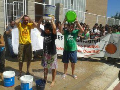 Alumnos del IES Masamagrell protestan volcando cubos de agua sobre sus cabezas.