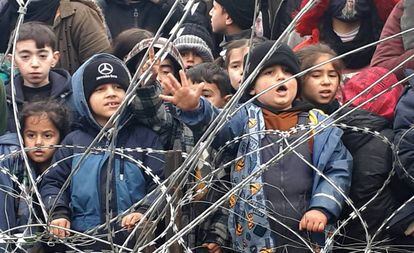 Niños migrantes se reúnen cerca de la valla en la frontera entre Polonia y Bielorrusia, cerca de Kuznica (Polonia), este jueves.