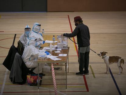 Un hombre deposita su voto en el polideportivo municipal España Industrial de Barcelona.