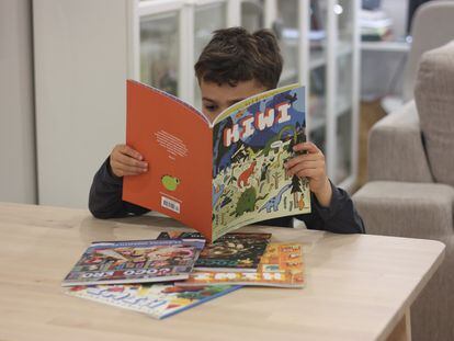 Un niño lee con interés 'Kiwi', revista infantil.