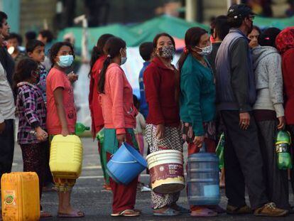 Un grup de nepalesos fan cua per obtenir aigua en un camp de desplaçats de Katmandú.