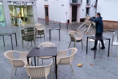 Un camarero recoge una terraza a las seis de la tarde, en Sevilla.