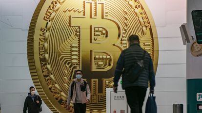 HONG KONG, CHINA - FEBRUARY 15: Pedestrians walk past an advertisement displaying a Bitcoin cryptocurrency token on February 15, 2022 in Hong Kong, China. Cryptocurrencies are gaining popularity worldwide as investors seek to diversify into the new asset class despite wild swings in the valuations of assets like Bitcoin and Ethereum in the first weeks of the year. Buying and selling crypto is becoming common in many places, like Hong Kong, where regulators have so far avoided using a heavy hand to manage crypto platforms. (Photo by Anthony Kwan/Getty Images)