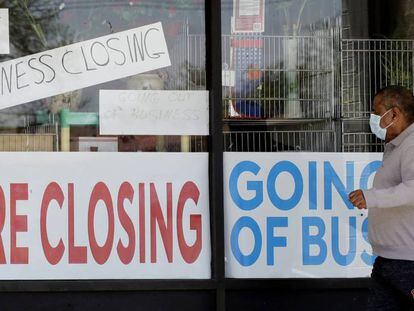 Un hombre mira un negocio con carteles de cierre en Niles, localidad del estado de Illinois (EE UU). 