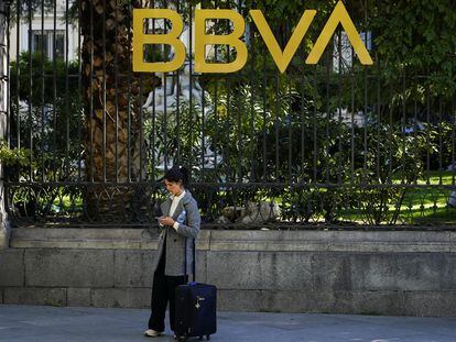 Una mujer en frente de un edificio del BBVA en Madrid.