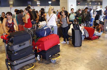 Un grupo de viajeros espera en el aeropuerto madrile&ntilde;o de Barajas.