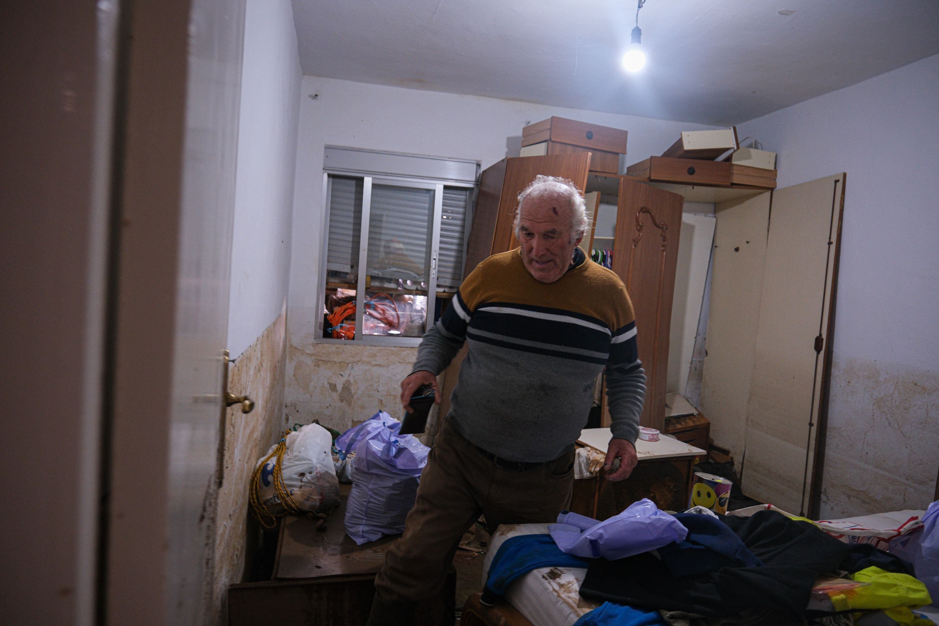 Justo Sáchez Abad, vecino de la localidad pacense afectada, camina por su dormitorio sorteando el barro y sus pertenencias. Justo fue rescatado del tejado de su casa de Valdebótoa por una barca de protección civil.