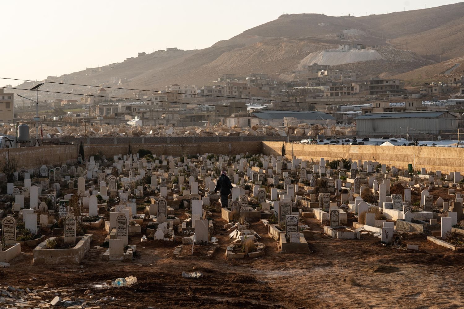 Un refugiado sirio visita una tumba del cementerio Al Abrar, en la localidad libanesa de Arsal.