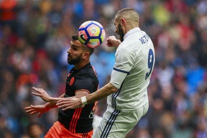 Karim Benzema (d) y Martín Montoya saltan para golpear el balón.