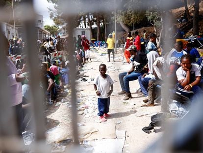 Un niño frente a la entrada del centro de acogida de inmigrantes de Lampedusa, el sábado.