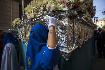 Un nazareno sostiene la imagen de una Virgen durante el Domingo de Ramos en Granada.