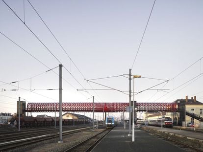 Esta brillante pasarela peatonal sobre las vías del TGV en La Roche-Sur-Yon, en la Francia atlántica, es una cilíndrica estructura de acero que rinde homenaje tanto al trabajo de Gustave Eiffel como al de Robert La Ricolais, innovador de la ingeniería y la arquitectura nacido allí. Obra de los equipos de París y Nueva York de Bernard Tschumi y Hugh Dutton, la pasarela responde a la premisa de arquitectura en movimiento, en diálogo con los trenes que pasan, en una atmósfera urbana e industrial enfatizada por su impactante color rojo.