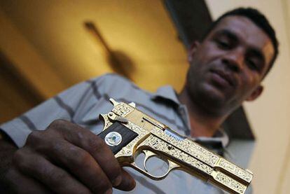 Un rebelde muestra una pistola dorada de Gadafi.