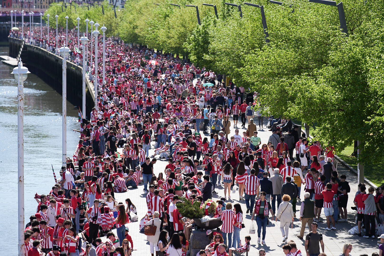 Centenares de aficionados del Athletic Club de Bilbao esperan en los márgenes de la ría del Nervión, este jueves en Bilbao. 