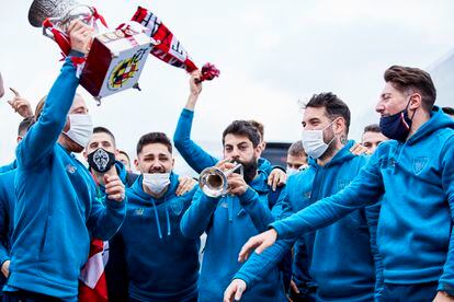 Asier Villalibre toca la trompeta mientras el resto de jugadores del Athletic cantan con el trofeo de la Supercopa.