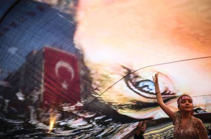 Una manifestante bajo un inmenso retrato de Mustafa Kemal Atat&uuml;rk, fundador de la Turqu&iacute;a republicana y laica, en una concentraci&oacute;n contra el golpe de Estado en la localidad turca de Esmirna organizada el 4 de agosto por la oposici&oacute;n socialdem&oacute;crata.  