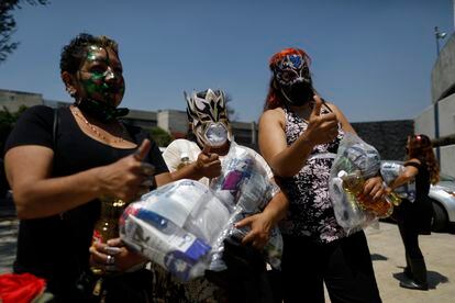 Las luchadoras Migala, La Fugitiva, y La Zorra, tras recoger una de las ayudas por parte del Comité de lucha libre de Ciudad de México.