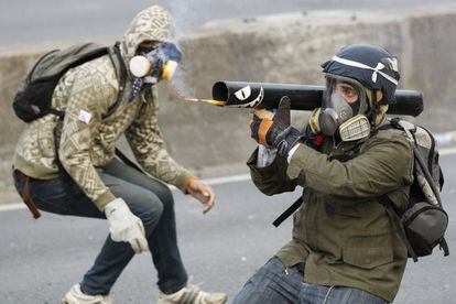 Un manifestante antigubernamental dispara un proyectil, de fabricación casera, a miembros de la policía en las calles de Caracas (Venezuela).